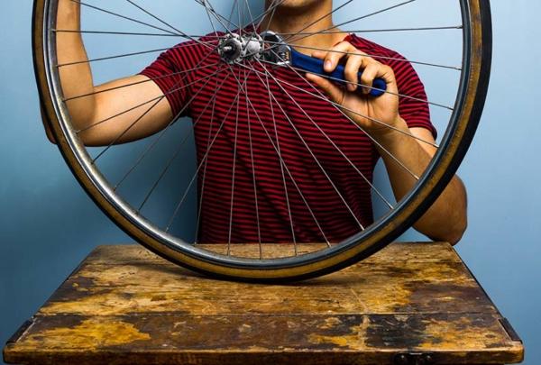 Man fixing bicycle wheel.